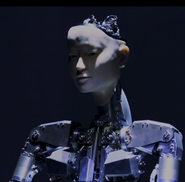 Alter3, an android with a human-like face and exposed metal body, lit against a dark background
